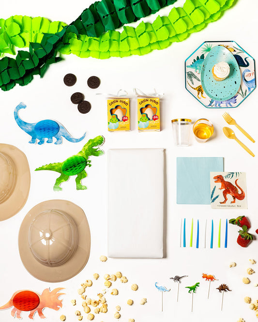 Dinosaur-themed birthday party pack with dino plates, cups, napkins, and decorations