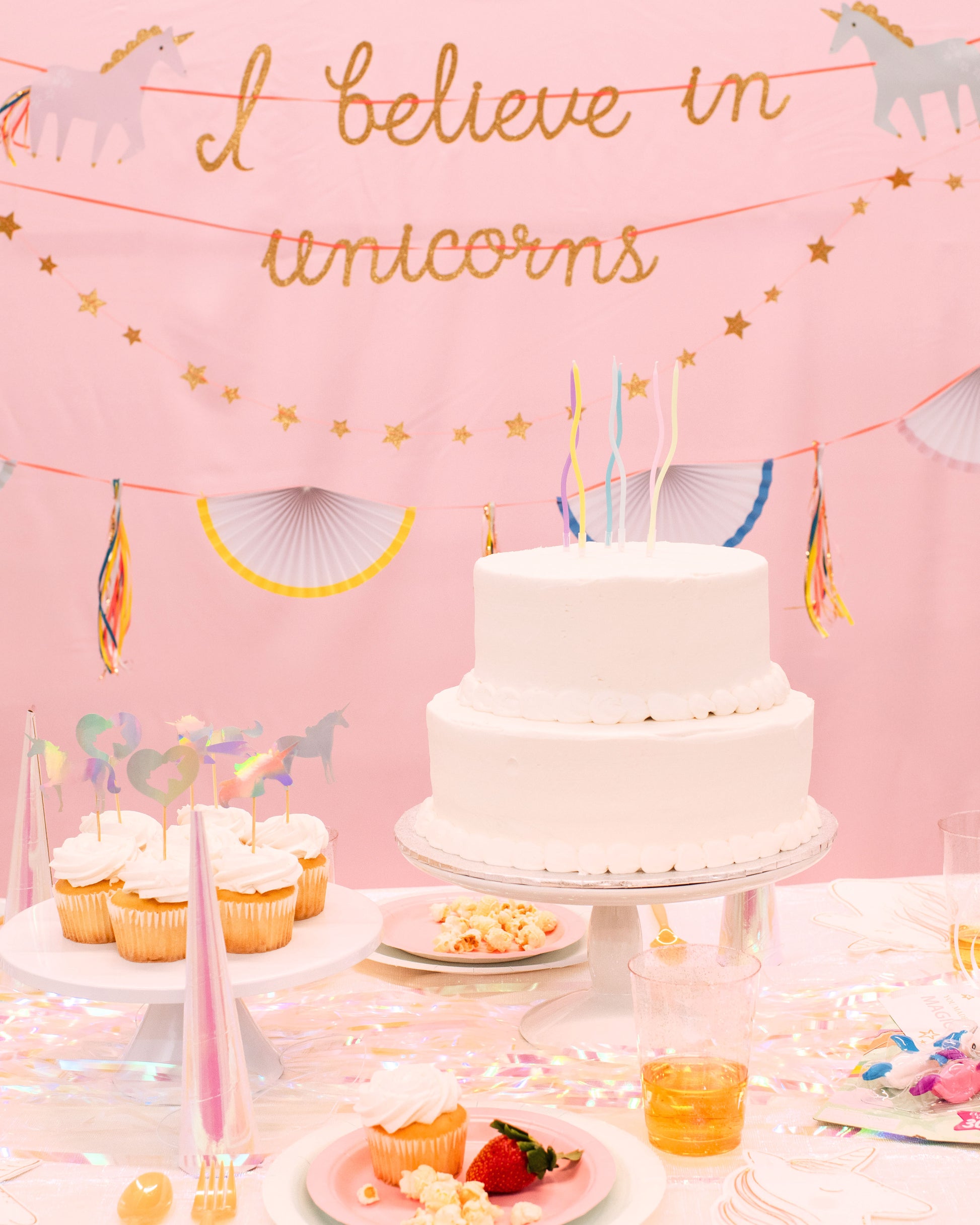 Whimsical unicorn birthday table setup with iridescent accents, pastel decor, and themed tableware