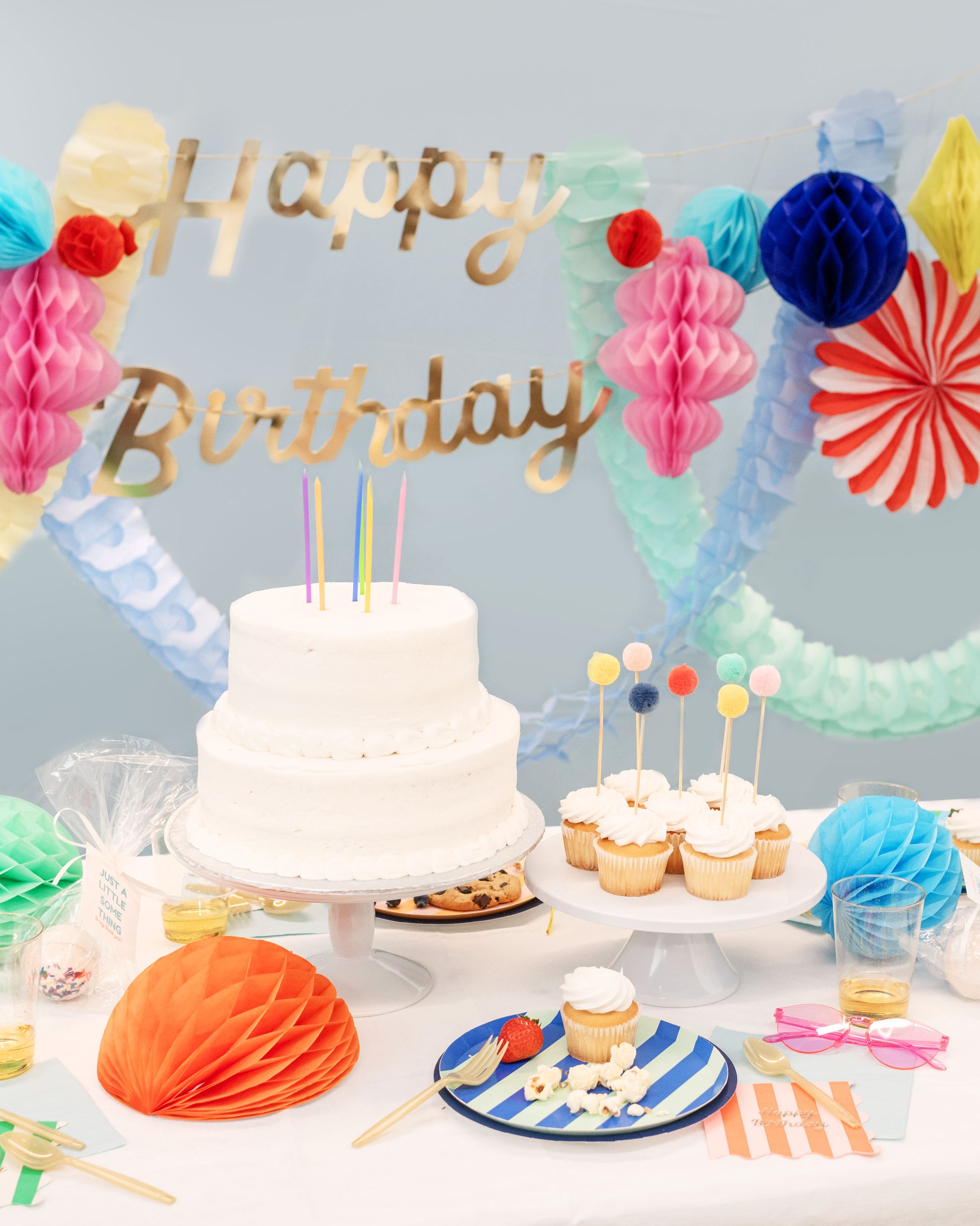 Bright and cheerful birthday party table with rainbow-themed decorations and confetti accents