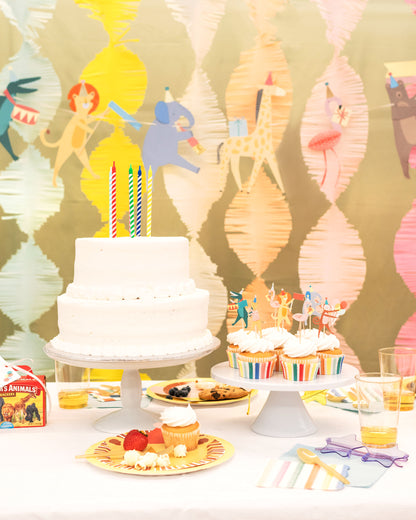 Animal-style birthday party table featuring wild animal decorations with party hats and bold animal accents